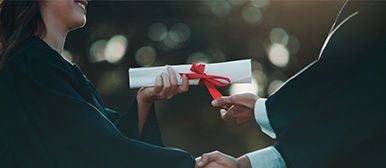 Einer jungen Frau wird ein Diplom überreicht