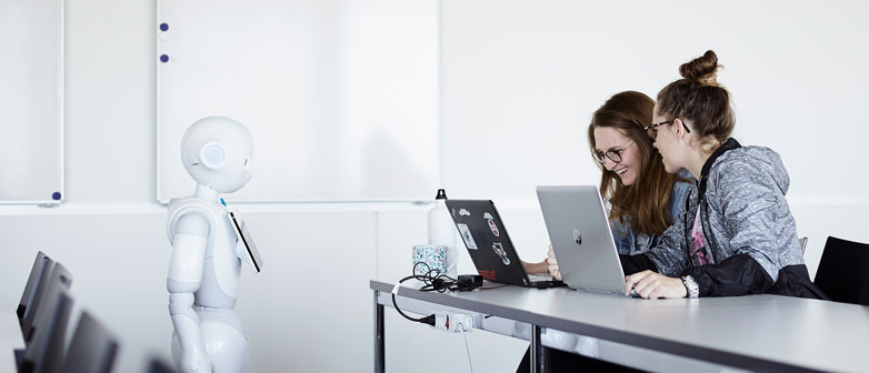 Zwei Studentinnen programmieren den Roboter Pepper