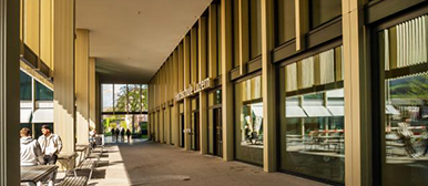 Aussenansicht Campus Rotkreuz mit Menschen, die draussen sitzen