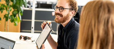 Man zeigt etwas auf seinem Laptop