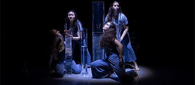 Drei Studentinnen im Rampenlicht vor einem Korb und daneben steht eine Leiter