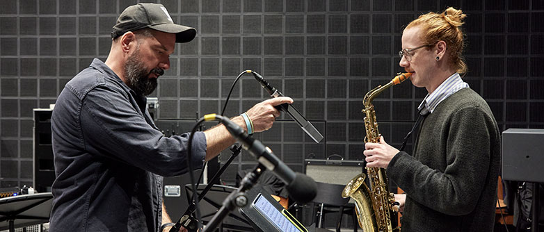 Dominik Burkhalter positioniert ein Mikrofon an einer Recording Session im Club Knox an der Hochschule Luzern – Musik. Bild HSLU/Christof Schürpf