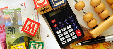 Banknotes, calculator and abacus symbolising scholarships and financial support.