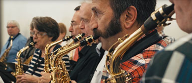 Eine Gruppe älterer Menschen musizieren zusammen. 