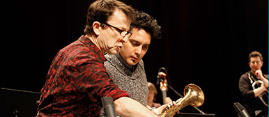 Franck Tortiller gibt einem Studierenden Anweiseungen wärhend einer Probe der Big Band. 