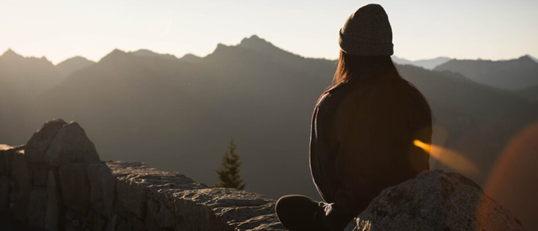 Frau auf einem Hügel bei Sonnenuntergang