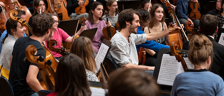 Musiker:innen und Musiker spielen in einem Orchester
