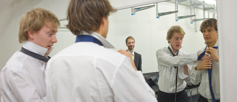 Männer stehen im Backstage binden Krawatten