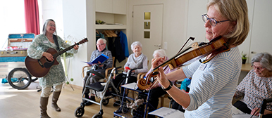 Senior:innen spielen Instrumente in einem Raum