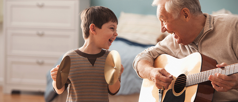Ein Mann und ein Kind spielen Musik zusammen mit Gitarre und Becken