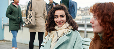 Studierende sitzen auf einer Terrasse und sprechen zusammen
