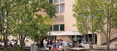 Menschen sitzen vor dem Gebäude der Hochschule Luzern - Musik