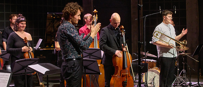 Jose Vaqzuez steht mit einem Ensemble auf der Bühne