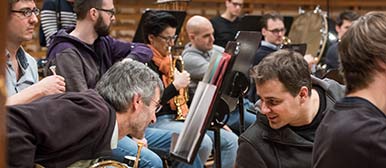 Ein Mitglied der Jungen Philharmonie tauscht sich mit einem Musiker des LSO bei einem gemeinsamen Auftritt im KKL Luzern aus. 