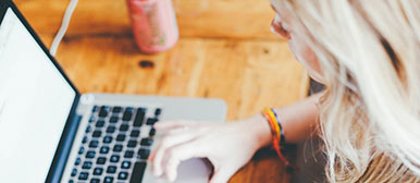 Studentin mit Laptop an externem Arbeitsplatz