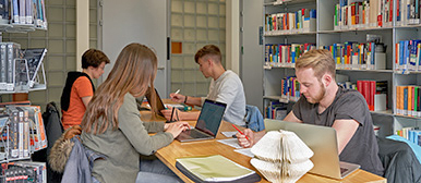 Mediothek, Studierende an ruhigen Arbeitsplätzen zwischen Regalen