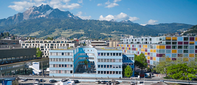 Das Departement Soziale Arbeit in Blau, im Hintergrund viele Häuser und der Pilatus