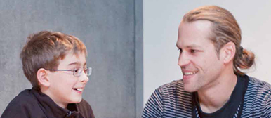 Ein Mann und ein Junge sitzen am Tisch und lachen