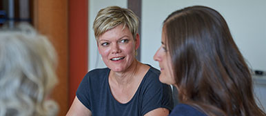 Drei Frauen in einer Besprechung, der Fokus liegt auf die Mittlere