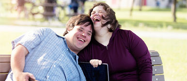 Zwei behinderte Menschen auf Parkbank