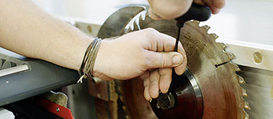 Hände schrauben an Säge