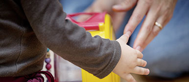 Die Hand eines Kindes und eines Erwachsenen berühren sich