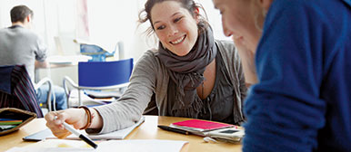 Zwei Frauen schauen im Unterricht auf ihre Unterlagen