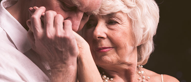 Senior küsst die Hand einer Seniorin
