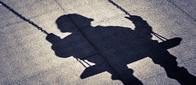 Schatten von einem Kind auf einer Schaukel