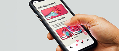 Eine Hand hält ein Handy mit einer Appstandort auf der Screen.