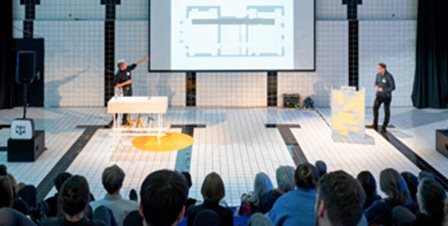 Zwei Personen präsentieren vor Publikum