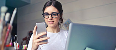 frau am smartphone mit laptop