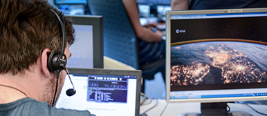 Mann vor mehreren Computerbildschirmen