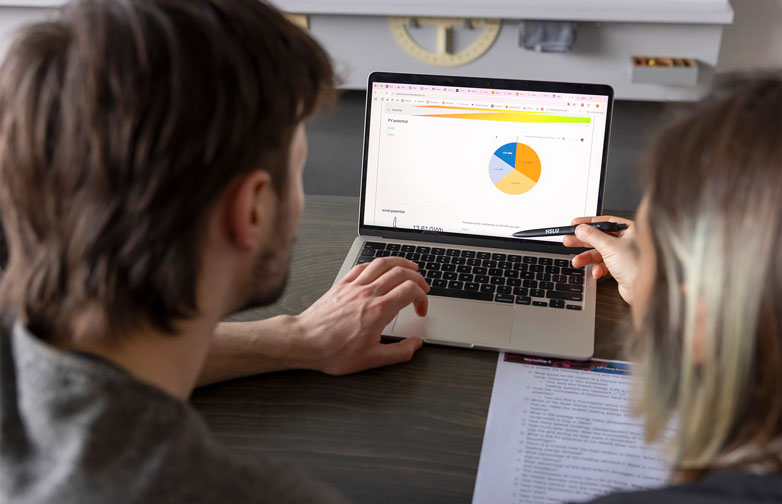 Zwei Forschende betrachten eine Visualisierung von Energiedaten