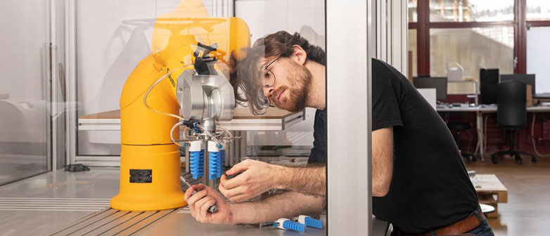 Young researcher working on robotic arm