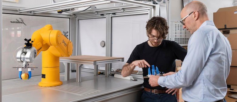Two people discussing parts in the robotics lab
