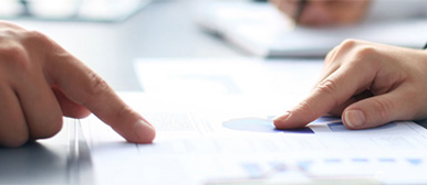 Zwei Hände zeigen auf Dokument