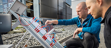 Men operate a panel with plug connections