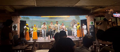 Gruppe aus der Schweiz tanzt mit Einheimischen auf der Bühne eines Clubs 