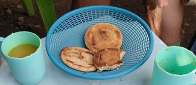Korb mit Brot und Tassen mit Fischsuppe auf einem Tisch