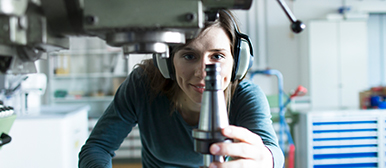 Woman holding a machine part