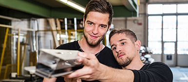 Two young engineers look at a metal rail