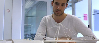 Student, der sich in einem Unterrichtszimmer ein weisses Modell betachtet