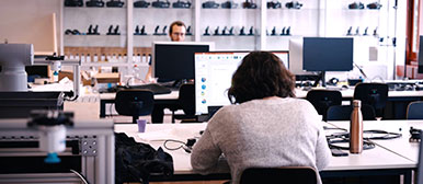 Eine Studentin, die an einem Pult im Digital Lab am Laptop arbeitet