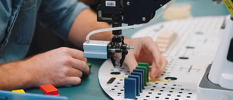 Hände die mit einer Maschine arbeiten