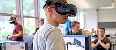 Junger Mann mit einer VR Brille auf dem Kopf