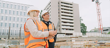 Eine Frau und ein Mann begutachten sich gemeinsam eine Baustelle