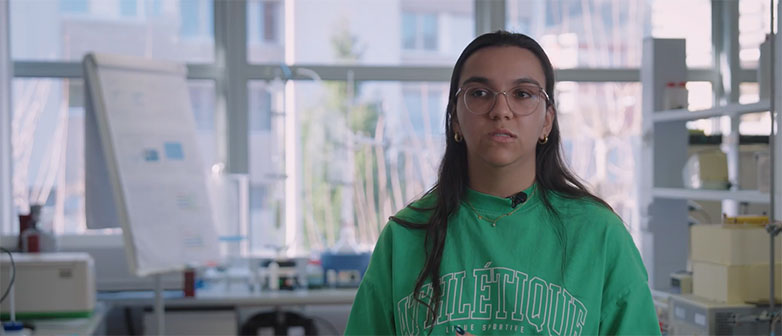 Woman speaking in an office with a flipchart in the background.