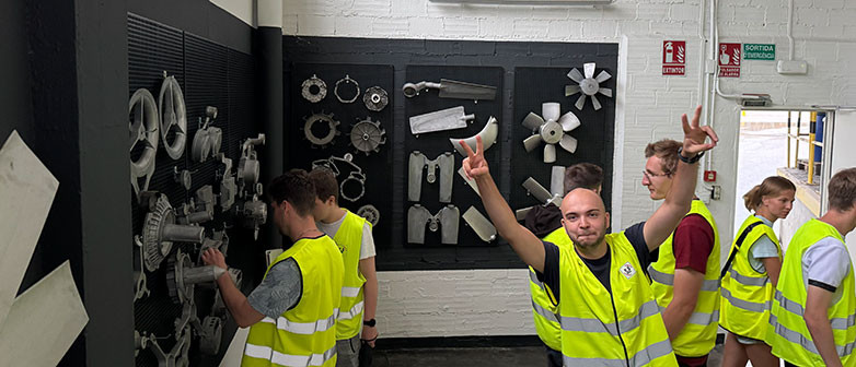 Gruppe in Warnwesten bei der Besichtigung technischer Bauteile und Maschinen.