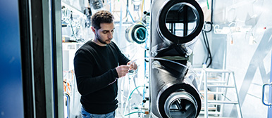 Ein Student begutachtet sich eine Heizungsanlage